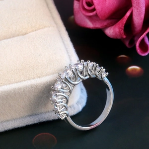 Close-up of silver prong-set zircon ring on beige velvet jewelry box with floral accents