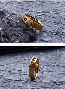 Detailed view of gold stainless steel ring with embossed DAD lettering and matte finish