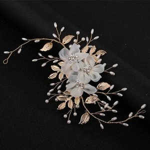 Detailed shot of bridal headband with golden leaves, white flowers and pearls