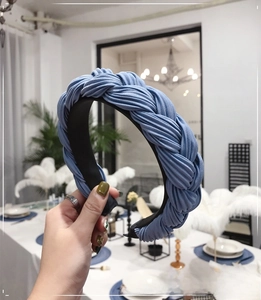 Detail of blue braided wide headband featuring fine fabric texture and non-slip lining