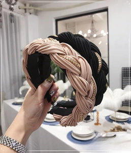 Dettaglio dei cerchietti intrecciati in nero e rosa cipria con catene in metallo oro