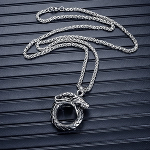 Detailed view of silver titanium steel Ouroboros dragon pendant with woven chain texture