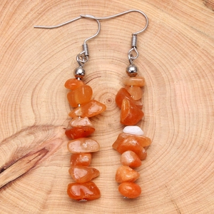 Natural orange stone drop earrings with stainless steel hooks on wood texture