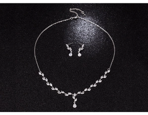 Dettaglio della collana a foglia d'argento con ciondolo a goccia in zircone su sfondo scintillante