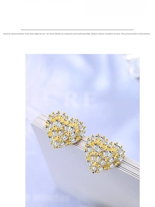 Detailed macro view of heart-shaped gold studs with glittering cubic zirconia stones