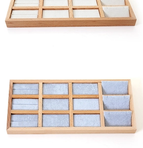 Detailed view of beige and light blue velvet lining inside a wooden jewelry organizer tray