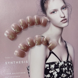 Short square gradient milk tea press-on nails with gold foil accents on magazine background