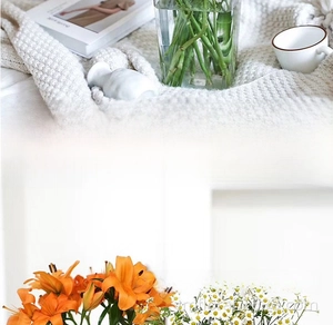 Detailed close-up of realistic orange lilies and white daisies in a clear flower bucket