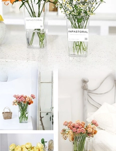 Close-up of a clear acrylic flower bucket with modern label and fresh floral arrangement