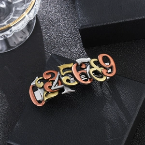 Detail of steampunk hair clip featuring metallic number charms in gold and silver finish