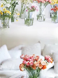 Modern clear acrylic square flower buckets with fresh roses in a minimalist setup