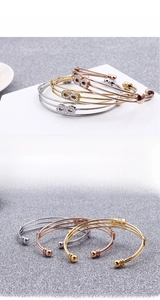 Détail de trois bracelets infini en or, argent et or rose sertis de cristaux brillants