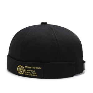 Classic black brimless docker hat in heavy cotton canvas with a yellow logo patch