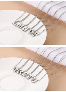 Detailed view of crystal-encrusted silver letter pendants from L to U on thin link chains