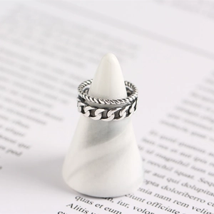 Detailed view of silver stackable rings with cable and rope chain textures on a display