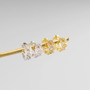 Close-up of gold and silver S925 sterling silver geometric chain earrings with pavé crystals