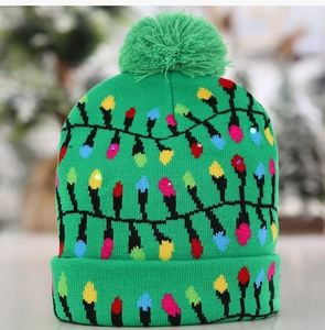Détail du bonnet de Noël vert à LED avec ampoules colorées et pompon festif doux
