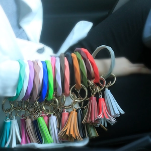 Close-up of colorful silicone ring keychains with leather tassels and gold metal rings