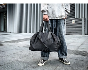 Outdoor shot of a black large capacity waterproof travel duffel bag for sports and fitness