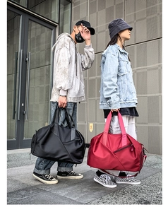 Outdoor shot of large waterproof travel bags in black and red for fitness and travel