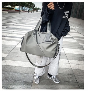 Close-up of gray nylon travel bag featuring diagonal stitching and hidden front zipper