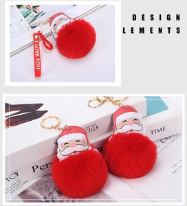 Detail of Santa Claus plush ball keychain with red leather accents and gold metal ring