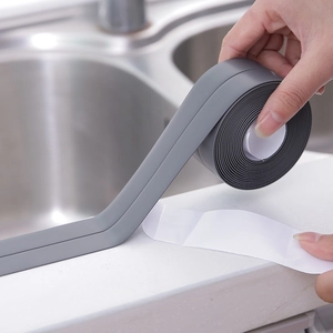 Ruban d'étanchéité gris imperméable appliqué entre l'évier en inox et le plan de travail