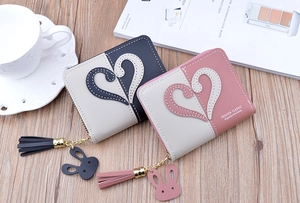 Detail of color-block mini wallets featuring heart embroidery and rabbit tassel charms