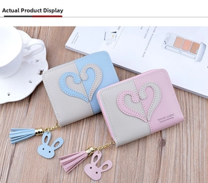 Detail of color-block mini wallets with heart patch, tassels and rabbit charm on wood
