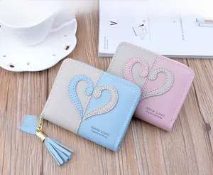 Detail of color-block mini coin purses with heart pattern, zipper, and rabbit charms