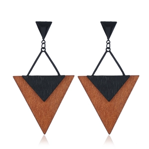 Vue détaillée des boucles d'oreilles géométriques en bois avec triangles noirs et bruns