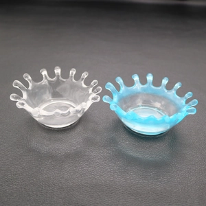 Overhead view of two splash-shaped resin jewelry dishes in clear and light blue finishes