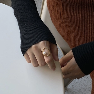 Detail of 925 sterling silver geometric ring with white pearl on model's index finger