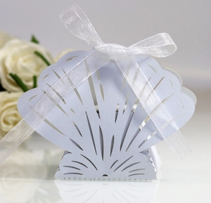 Detailed laser-cut shell-shaped favor box in white with silk ribbon for weddings