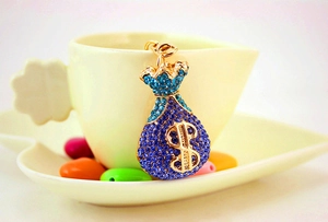 Macro view of a gold money bag keychain with blue crystals and a dollar sign