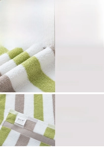 Close-up of three-color striped thick cotton towel with soft texture and brand label