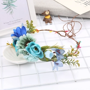 Detailed shot of handmade blue silk flower crown headpiece with berries and green leaves