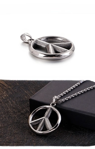 Detail of vintage silver peace sign pendant with distressed texture on twisted rope chain