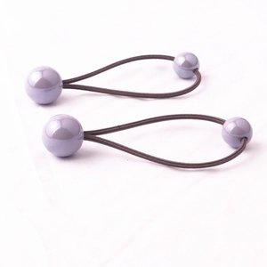 Dettaglio di elastici per capelli con perle viola e fasce marroni per bambine