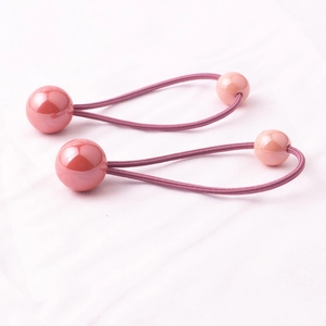 Primo piano di elastici per capelli con perle rosa per bambine su tessuto morbido