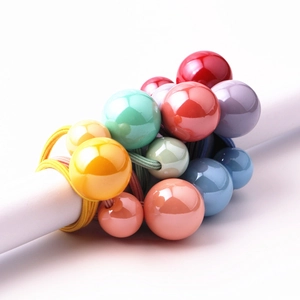 Dettaglio di un elastico per capelli con perline colorate in tonalità pastello