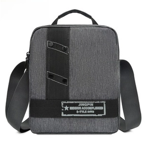 Detailed view of dark grey canvas messenger bag with vertical straps and metal rivets