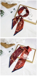 Detail of red-brown silk scarf with chain patterns and blue borders on a chic background