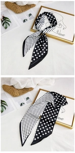 Detail of long silk scarf with black and white polka dots showing soft texture and style
