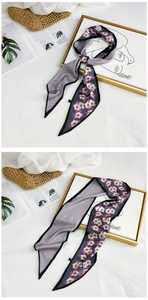 Detail of floral and plaid silk scarf tied as a bag accessory on a stylish background