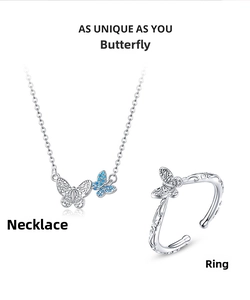 Detailed view of silver butterfly necklace and open ring set with blue crystal stones