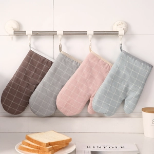 Quilted cotton heat resistant oven mitts with hanging loops in four colors hanging on a wall