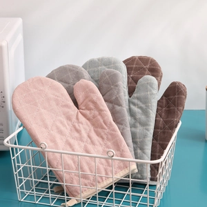 Close-up of quilted heat resistant oven mitts in various colors stored in a metal basket
