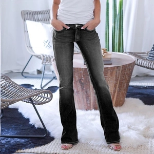 Détail du jean évasé gris foncé avec effet délavé vintage sur la texture du denim