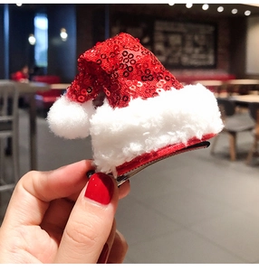 Close-up of a red sequin Christmas hat hair clip with plush trim and metal duckbill clip